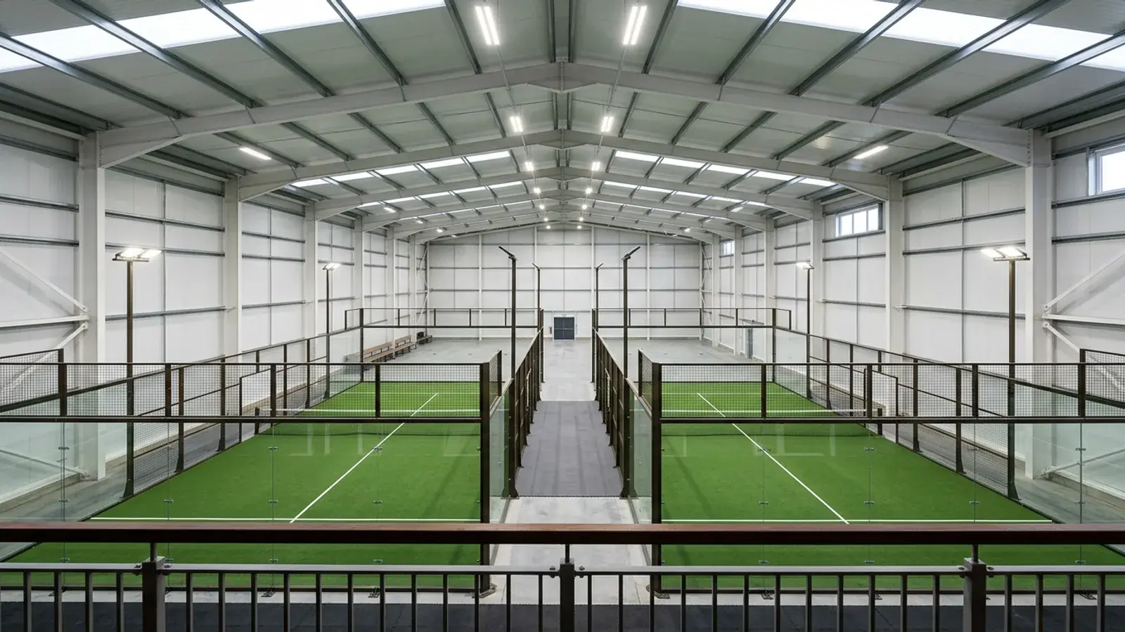 Blick von der Galerie in eine Leichtbauhalle mit zwei Padel-Courts und LED-Hallenleuchten